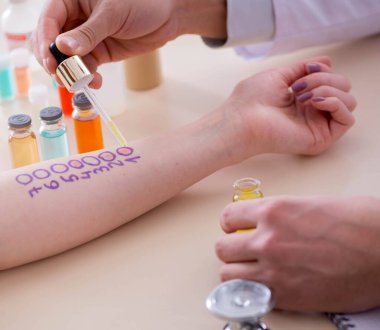 Hastanedeki hastanın alerji reaksiyonunu test eden doktor.