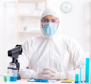 Laboratuvarda kimyasallar üzerinde çalışan genç bir kimyager.