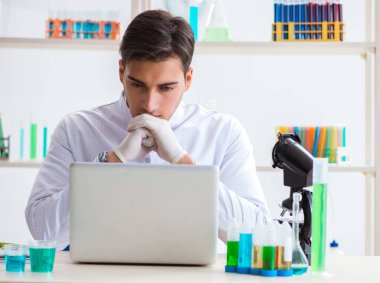 Kimya laboratuvarında deneyler yapan bir erkek öğrenci.