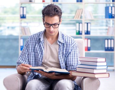 Öğrenci kitap okuyor ve kütüphanede sınavlara hazırlanıyor