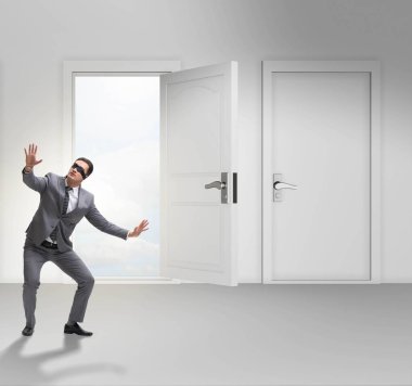 Kapıların önünde kafası karışmış bir iş adamı.