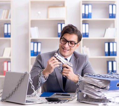 Ofis masasına zincirlenmiş meşgul bir çalışan.