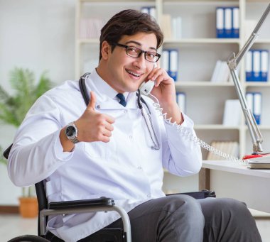 Hastanede çalışan tekerlekli sandalyedeki engelli doktor.