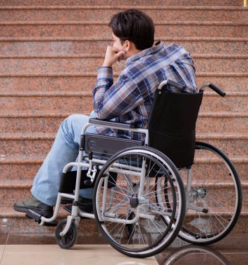 Tekerlekli sandalyedeki engelli adam merdivenlerde sorun yaşıyor.