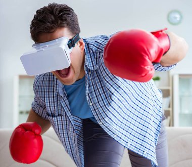 Sanal gerçeklik gözlüğü takan adam boks oyunu oynuyor.