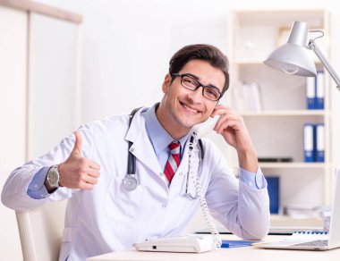 Hastane odasında çalışan yakışıklı genç bir doktor.