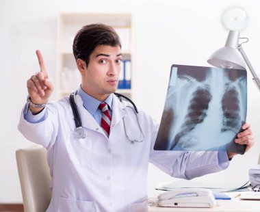 Hastane odasında çalışan yakışıklı genç bir doktor.