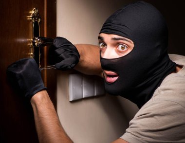 Suç mahallinde kar maskesi takan bir hırsız.