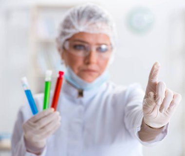 Laboratuvarda sanal düğmeye basan kadın kimyager.