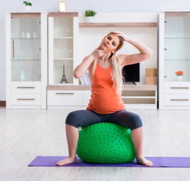 Evde doğum egzersizi yapmaya hazırlanan genç bir kadın.