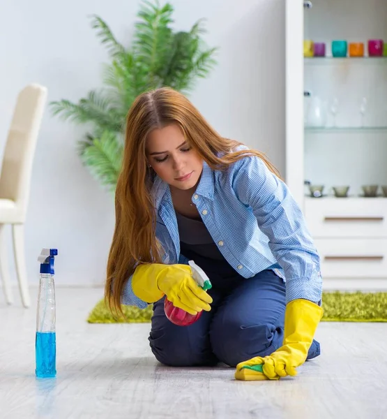 Young woman cleaning floor at home doing chores