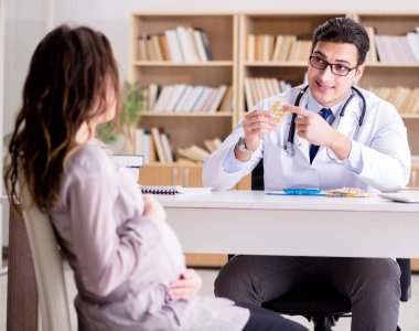 Hamile kadın muayene için doktoru ziyaret ediyor.