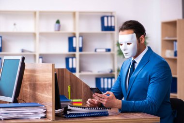 Ofiste maske takan genç bir erkek.