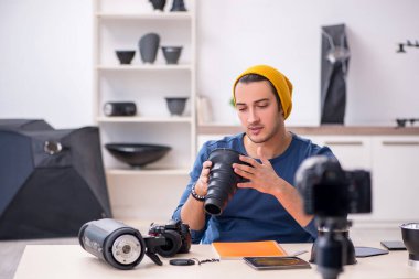 Genç erkek fotoğrafçı bloğu için video kaydediyor.
