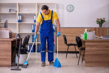 Genç müteahhit ofisi temizliyor.