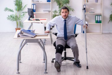 Ofiste çalışan genç bacağı yaralı bir çalışan.