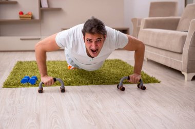 Genç adam evde spor yapıyor.