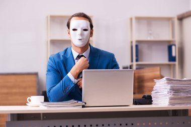 Ofiste maske takan genç bir erkek.