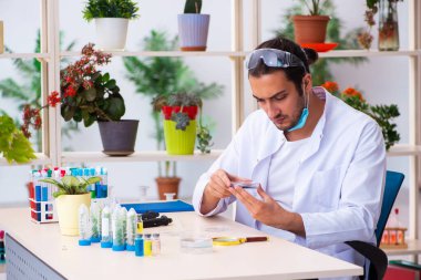 Laboratuvarda çalışan genç erkek kimyager parfümcüsü.