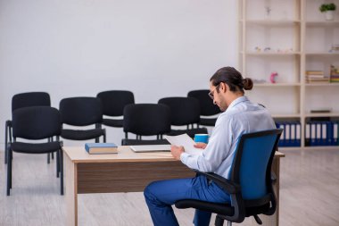 Genç erkek patron salgın sırasında ofiste seminer veriyor.