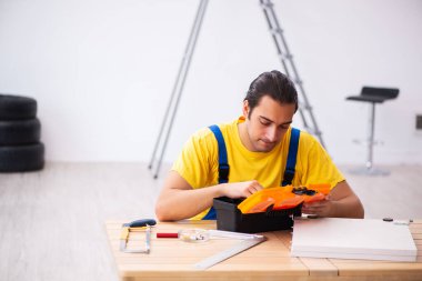 Genç erkek marangoz içeride çalışıyor.