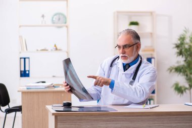 Hastanede çalışan yaşlı doktor radyoloji uzmanı.