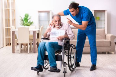 Old man in wheel-chair and young bad caregiver indoors clipart