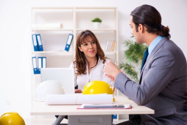 Genç işadamı ve bayan mimar yeni projeyi tartışıyor