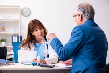 Yaşlı işadamı genç bayan doktoru ziyaret ediyor