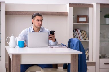 Evde çalışan genç bir erkek.