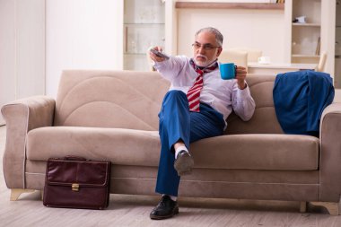 Evde televizyon izleyen yaşlı bir patron.