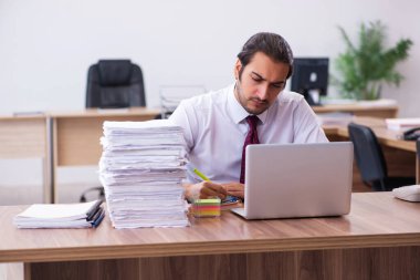 Ofisteki aşırı işten memnun olmayan genç bir erkek işçi.