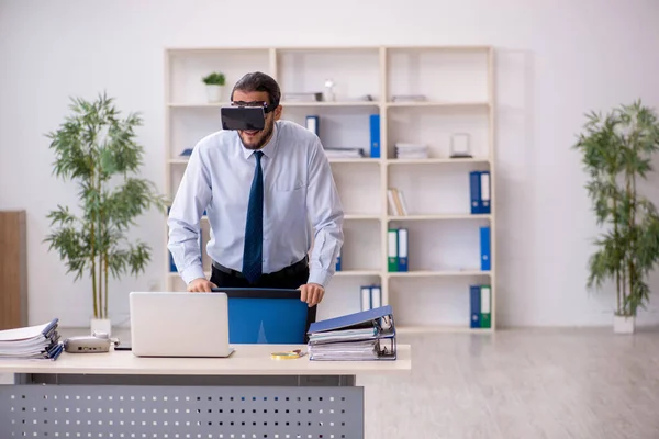 İş yerinde sanal gözlük takan genç bir erkek çalışan.