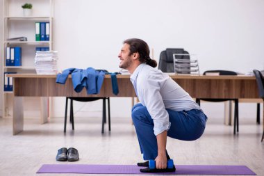 Mola sırasında spor yapan genç erkek çalışanlar.