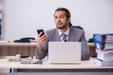 Ofisteki aşırı işten memnun olmayan genç bir erkek işçi.