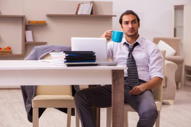 Genç erkek çalışan salgın sırasında evden çalışıyor.