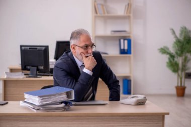 Ofiste oturan yaşlı işadamı