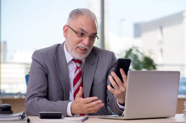 Ofiste çalışan yaşlı işadamı.