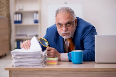 Ofiste oturan eski bir işadamı.