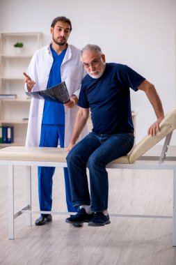 Yaşlı erkek hasta genç erkek doktor radyolojisti ziyaret ediyor.