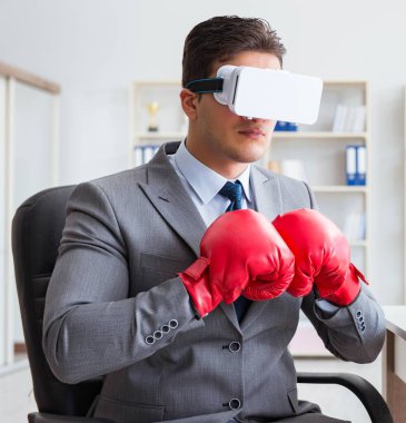 Sanal gerçeklik gözlüklü bir adam ofiste boks yapıyor.