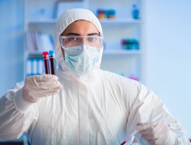 Laboratuvar asistanı hastanede kan örneklerini test ediyor.