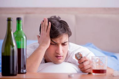 Yatakta içen alkolik adam depresyona giriyor.