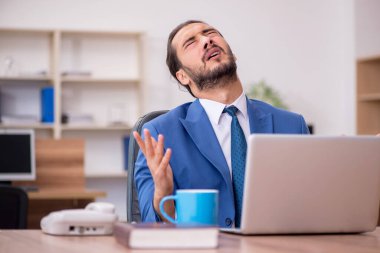 Ofiste çalışan genç bir erkek.