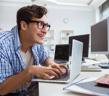 Birçok ekranın önünde oturan bir iş adamı