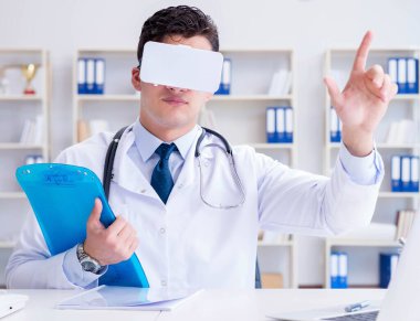 Sanal gerçeklik kulaklığı olan genç doktor ofiste çalışıyor.