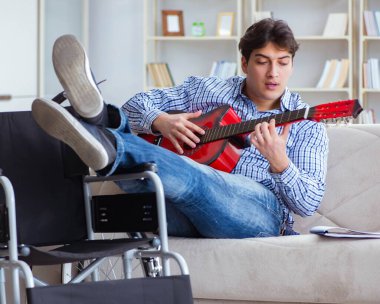 Evde gitar çalan engelli adam