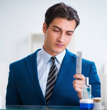 Adam banyoda çalışmak için giyiniyor.