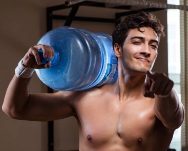 Büyük su şişeli kaslı adam.