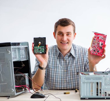 Genç teknisyen atölyede bilgisayar tamir ediyor.